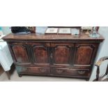 An 18th century oak mule chest with hinged lid, 4 arched and field panels and 2 drawers, on block