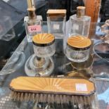 A pair of art deco silver mounted scent bottles, three matching jars and a clothes brush, all