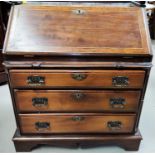 An unusual mahogany dwarf bureau with boxwood line inlay, fall front, spindle gallery, fitted and