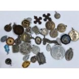 A collection of white metal religious pendants, tokens etc. mainly Christian.