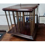 An early 20th century mahogany and brass table top revolving bookcase with Patent Office Designs