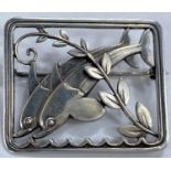 Georg Jensen:  a silver pierced rectangular brooch with twin leaping dolphins and diagonal frond,