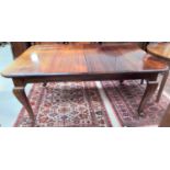 An early 20th century mahogany wind out dining table, 2 spare leaves