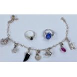 A white metal charm bracelet with charms stamped '925'; 2 white metal stone set dress rings