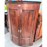 A Georgian inlaid mahogany corner cupboard with bow front enclosed by 2 doors