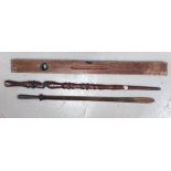 An African carved wooden spear with metal attachment and a vintage level.