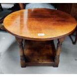 A distressed oak 2 tier coffee table with circular top in the manner of Titchmarsh & Goodwin; a