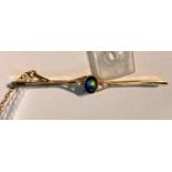 A yellow metal bar brooch set central black opal and 2 seed pearls, stamped '15ct', 3 gm