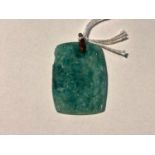 A turquoise jade coloured rectangular pendant in the Chinese manner, with relief decoration of