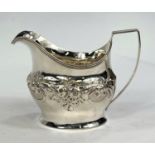 A Georgian hallmarked silver milk jug with embossed floral decoration, London 1806, 3.6oz.