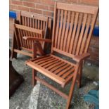 A pair of modern teak slat back reclining garden chairs
