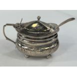 A Georgian hallmarked silver hinged sugar pot with embossed decoration and Bristol blue glass liner,