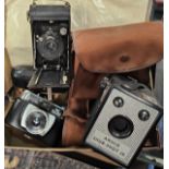 A miniature of 'Brixham Trawler and three vintage cameras.