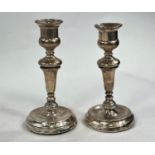 A pair of hallmarked silver candlesticks, London 1920 ( areas of denting/wear) and two hallmarked