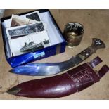 A selection of vintage postcards and a kukri
