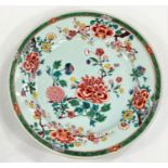 A Chinese 18th century famille vert plate with floral decoration, dia. 23cm
