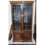 An early 20th century walnut display cabinet enclosed by 2 leaded glass doors, with double