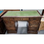 An Edwardian stained oak kneehole desk with inset green leather top, 3 frieze drawers and 6 pedestal