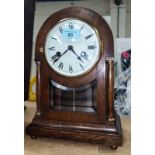 An early 20th century circular top oak marble clock with side pillars and striking movement
