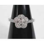 An 9ct hallmarked white gold and diamond lady's dress ring with central flowerhead setting and