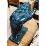 A large sculpture of a hand with palm facing upwards, on plinth, 33cm x 33cm