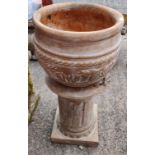 A terracotta garden urn on stand