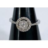 A platinum lady's dress ring with 2 tier 26 diamond flowerhead centre with diamond chips to each