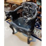 A late 19th/early 20th century carved/ebonised Chinese armchair with dragon armrests, carved knurled
