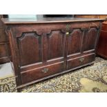 An 18th century oak panelled front mule chest with hinged top, double drawers below