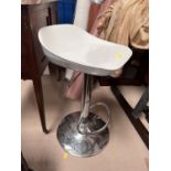 A modern chrome and white bar stool with rise and fall action