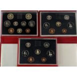Three red cased coin sets, 1987, 1988 and 1989