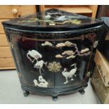 A modern Chinese 2 door corner cupboard in black lacquer, decorated with birds in relief, height