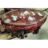 A modern Chinese coffee table with oval top, red lacquered and raised mother-of-pearl figures; etc.;