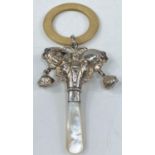 A hallmarked silver teething ring in the form of a butterfly with bells and mother-of-pearl handle