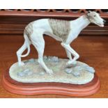 A Border Fine Arts figure of a greyhound, signed M Turner, on wooden base, length 20cm