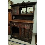 A Victorian oak dresser with extensive carved decoration, raised mirror back with shelf and cupboard