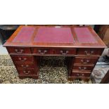 A mahogany reproduction kneehole desk with inset top, 3 frieze and 6 pedestal drawers