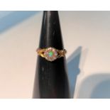 An 18 carat hallmarked gold ring with opal and diamonds in flower head cluster setting, with twin