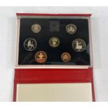 Three coin sets, two red, one blue case 1984, 1985 and 1986