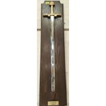A decorative wall hanging depicting "Sword of Charlemagne", on wooden backing, with label, 96cm