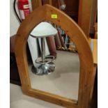 An arch top wall mirror in pine frame