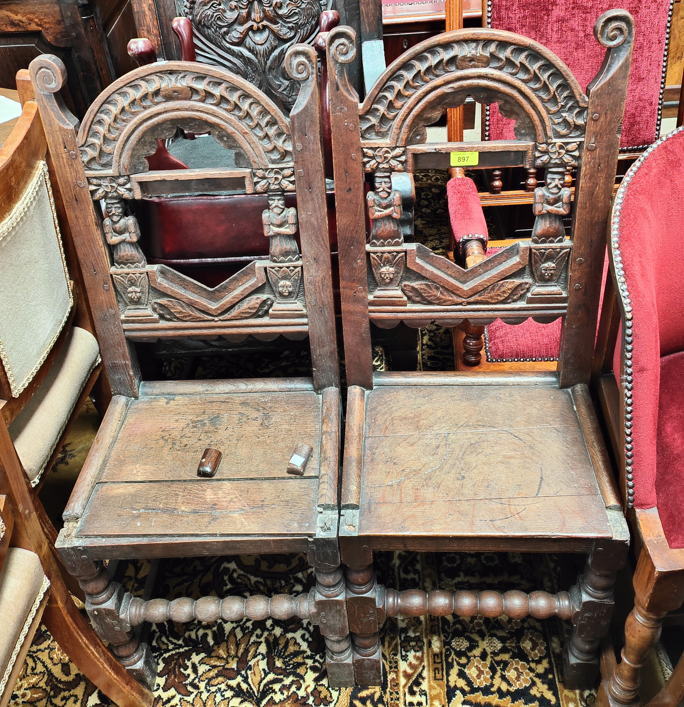 A 17th century style pair of oak Lancashire chairs, with carved backs and figural columns ( some