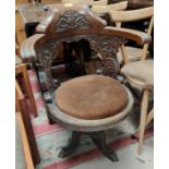 A late 19th/early 20th century ships captain chair in carved oak on cast iron base