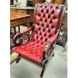 A deep button back arm chair with red leather