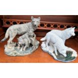 A Nemesis white resin group:  white wolves drinking from a stream; another:  wolf mother and cubs