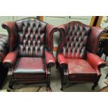 A pair of Georgian style wing back armchairs in deeply buttoned oxblood hide