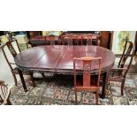 A Chinese hardwood dining suite comprising table with rounded extending top, 3 spare leaves,