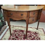 A Georgian mahogany demi-lune sideboard with cupboard and drawer below, on tapering legs.