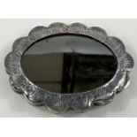 A white metal Turkish wedding mirror, stamped 900, oval shaped with embossed floral decoration
