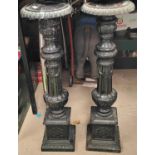 A Victorian pair of cast iron floor standing candlesticks on fluted columns and square bases, height
